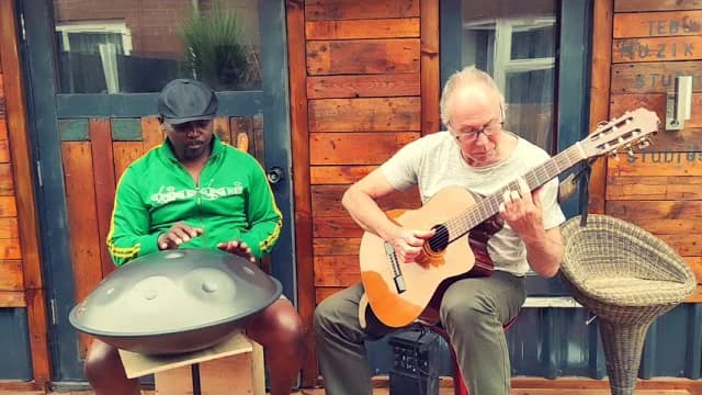 Handpan and classical guitar played side by side outside a timber-clad studio