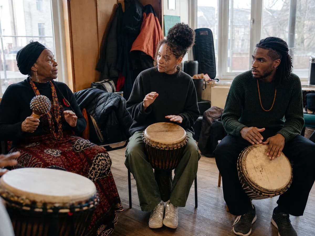 Participants in a rhythm circle clapping and playing hand percussion together