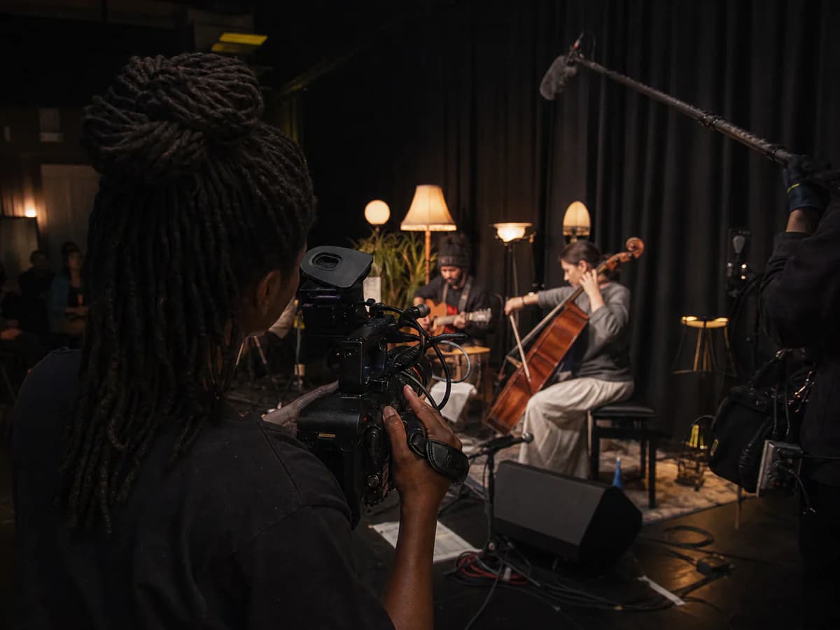 Filmmaker documenting a live studio encounter from the wings with cinema camera