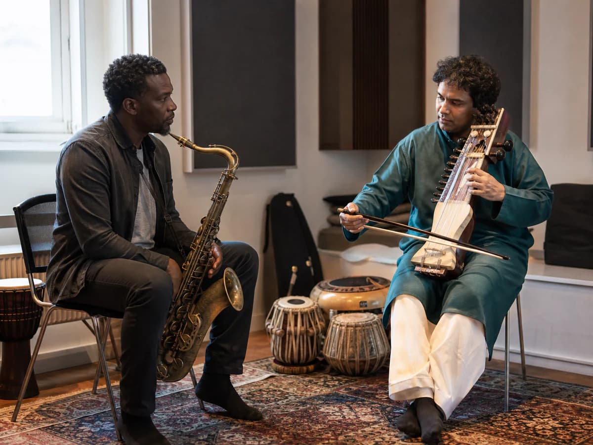 Saxophonist and sarangi player exchanging a phrase in rehearsal
